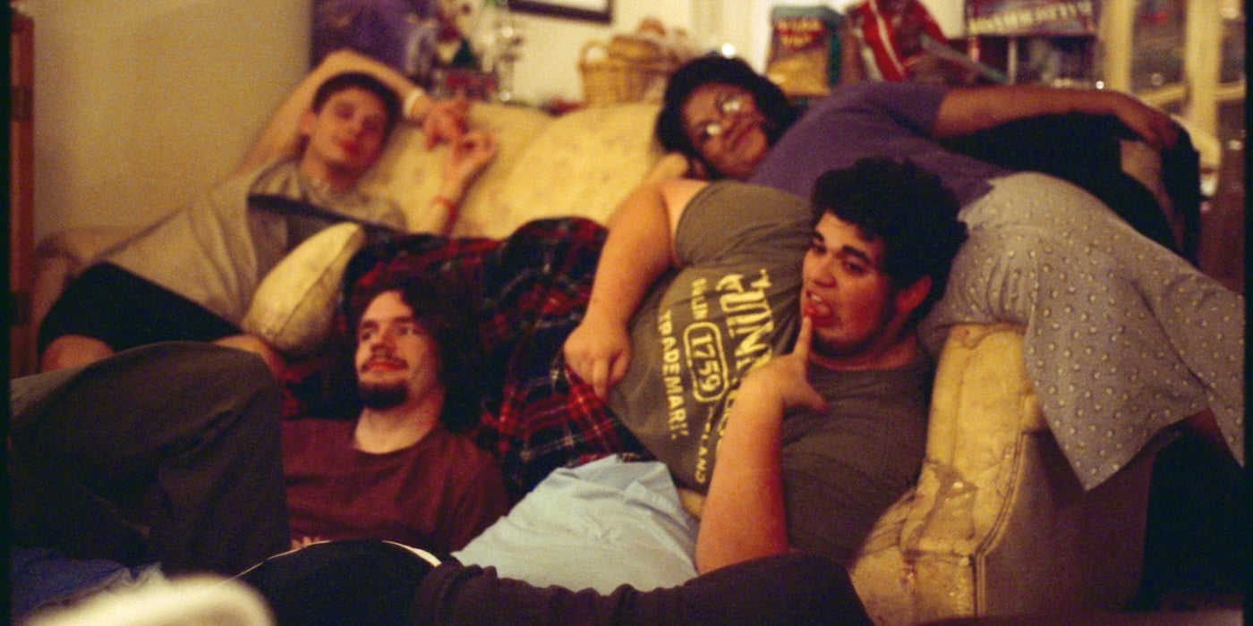 An image of a group of people piled on a couch during a sleepover.